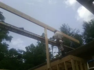 Carpenter setting a ridge beam over a new addition frame — Ice Dam Removal by Roofing Brothers in Honea Path