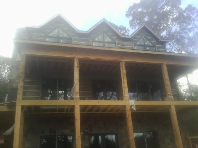 Dormers and porch framing on a large log home under construction — Roof Coating work by our crew in Honea Path